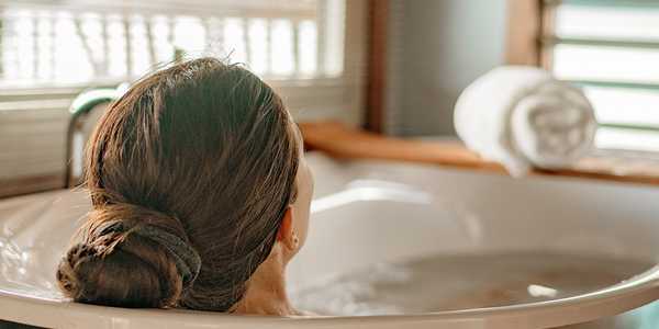 A woman relaxing in a bath tub.